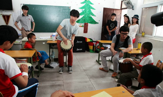 白杰（右三）和乐队老师教小朋友们打非洲鼓